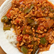 Ground chicken unstuffed pepper skillet with chopped green peppers, onions, and tomatoes served over rice.
