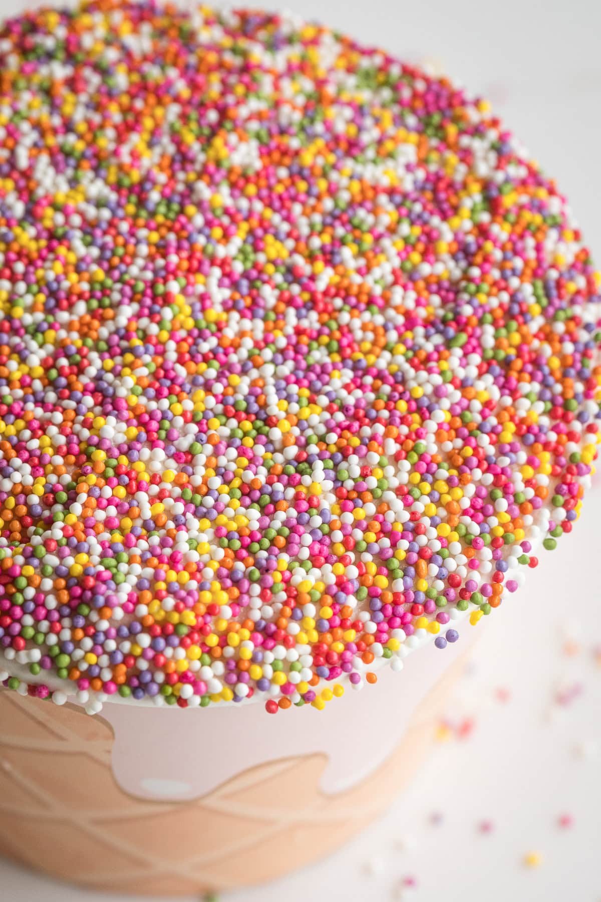 close up of nonpareils topped frosting with cake in a snack cup.