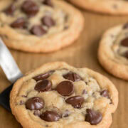 Freshly baked gluten-free chocolate chip cookies with crisp golden edges, soft centers, and melted chocolate chips on a spatula.