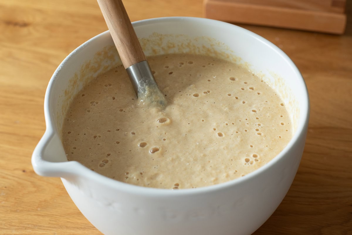 fresh milled flour pancake batter in a white bowl with danish wishk inside.
