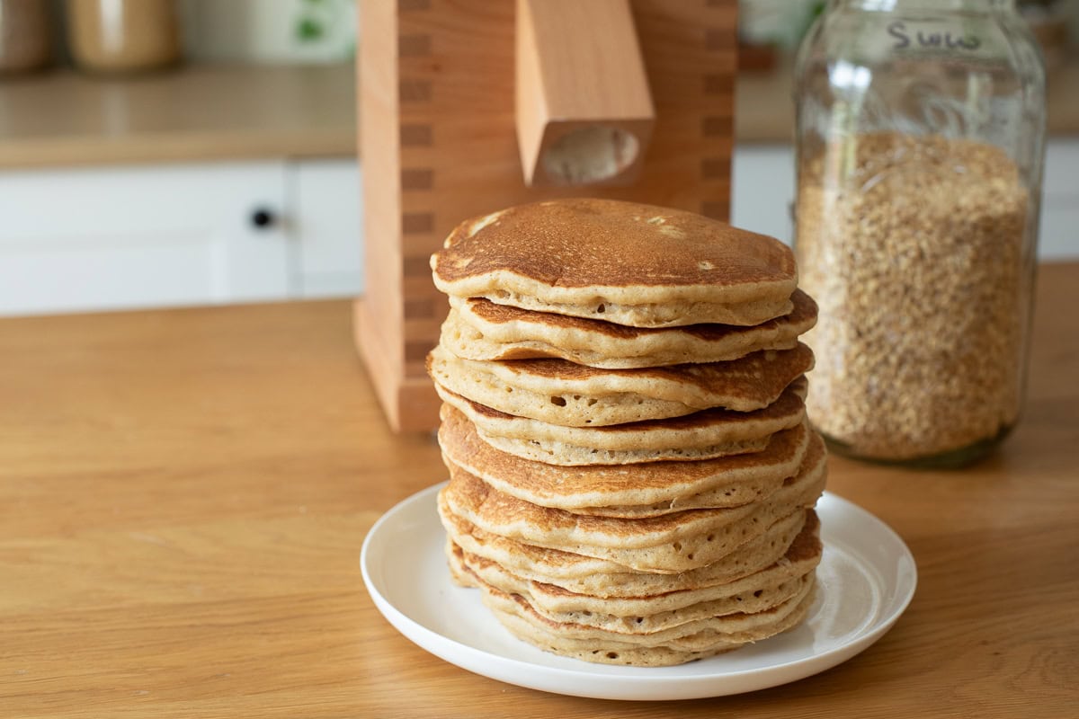 large stack of pancakes in front of komo vienna grain mill.