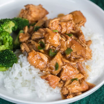 Slow cooker chicken teriyaki over rice with broccoli on a white plate.