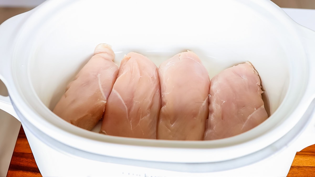 Four chicken breasts in slow cooker crockpot.