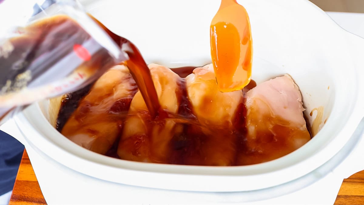 Homemade teriyaki sauce pouring into a crockpot.