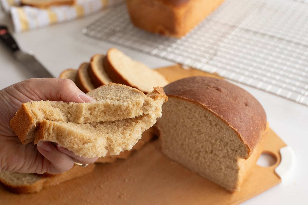 Freshly sliced homemade bread on a wooden cutting board.