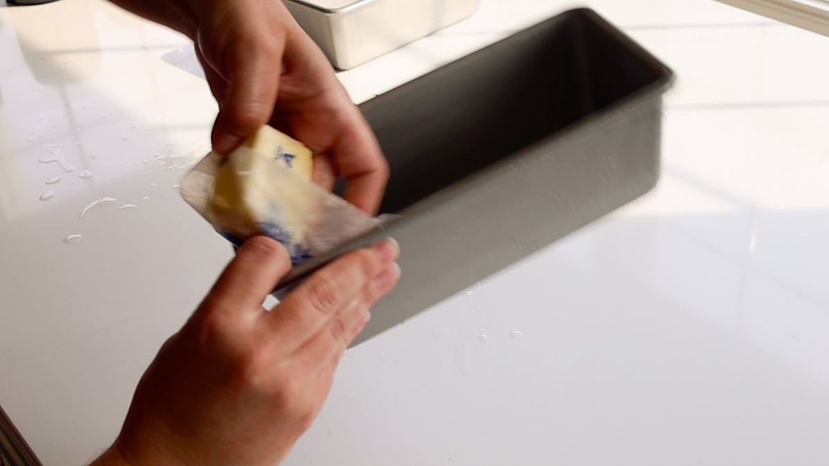greasing loaf pans with butter.