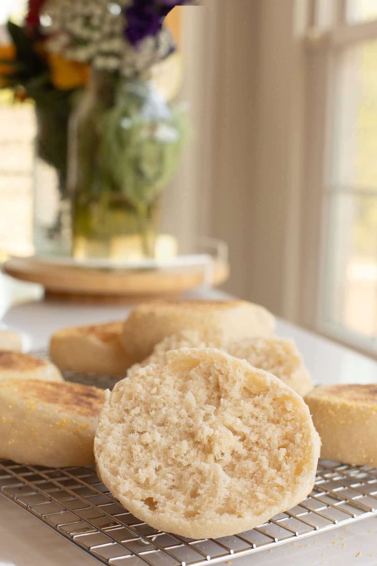 inside of homemade english muffins showing the nooks and crannies on cooling rack.