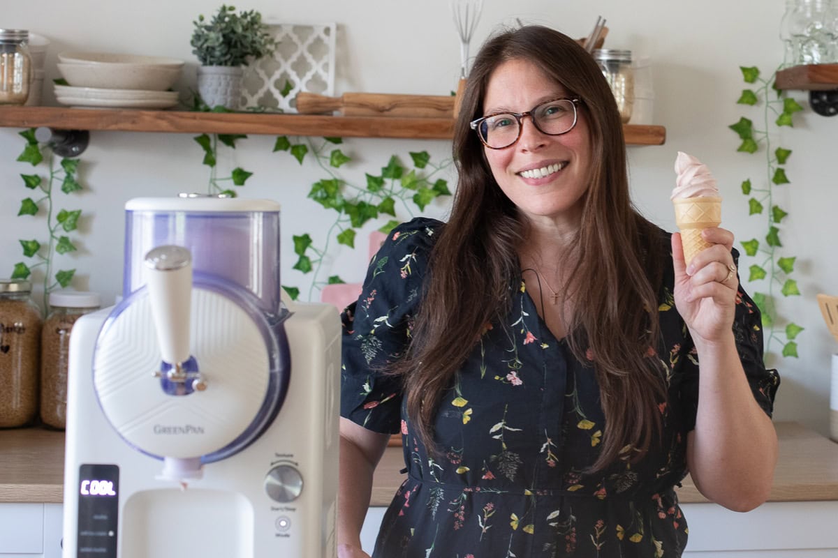 Courtney holding soft serve ice cream in a cone next to her greenpan frost. 