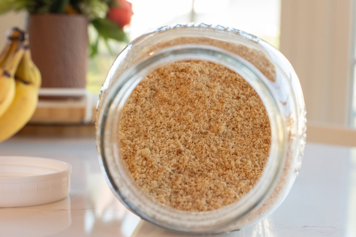 Close u of fresh milled flour bread crumbs in glass mason jar.