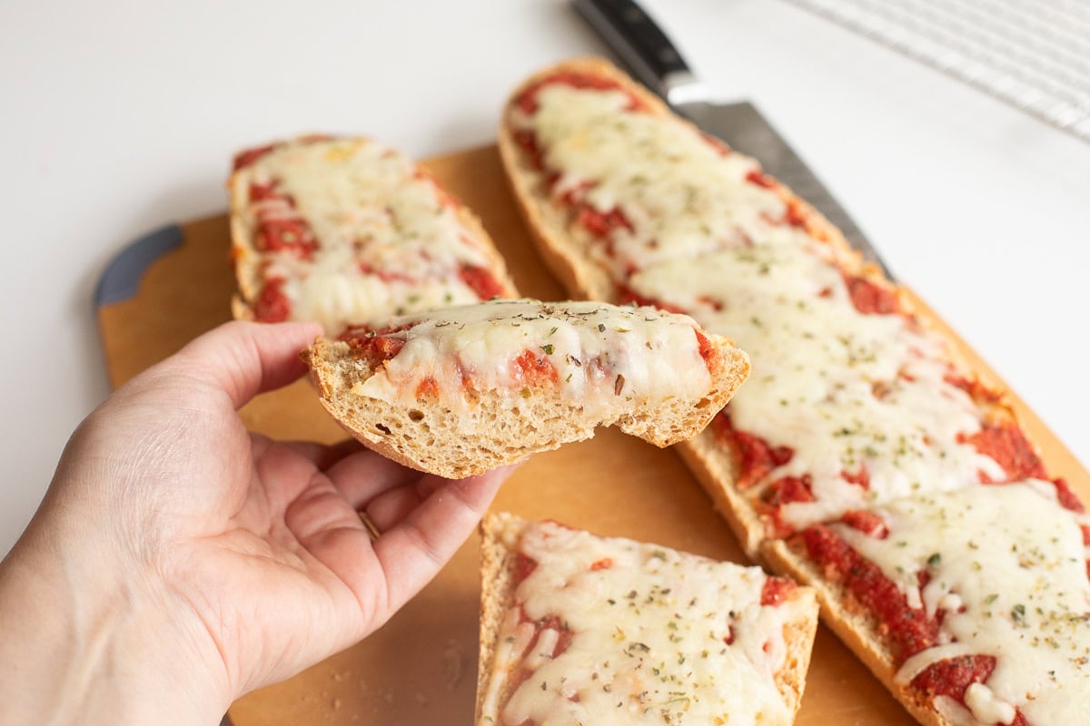 Hand holding Fresh Milled Flour French Bread Pizza showing interior shot of the bread too.