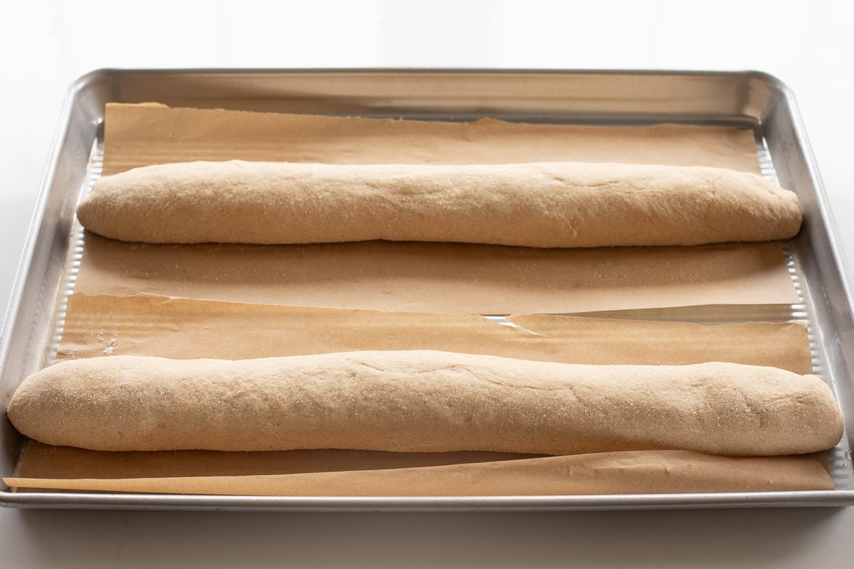 shaped french bread dough using fresh milled flour on parchment lined baking sheet.