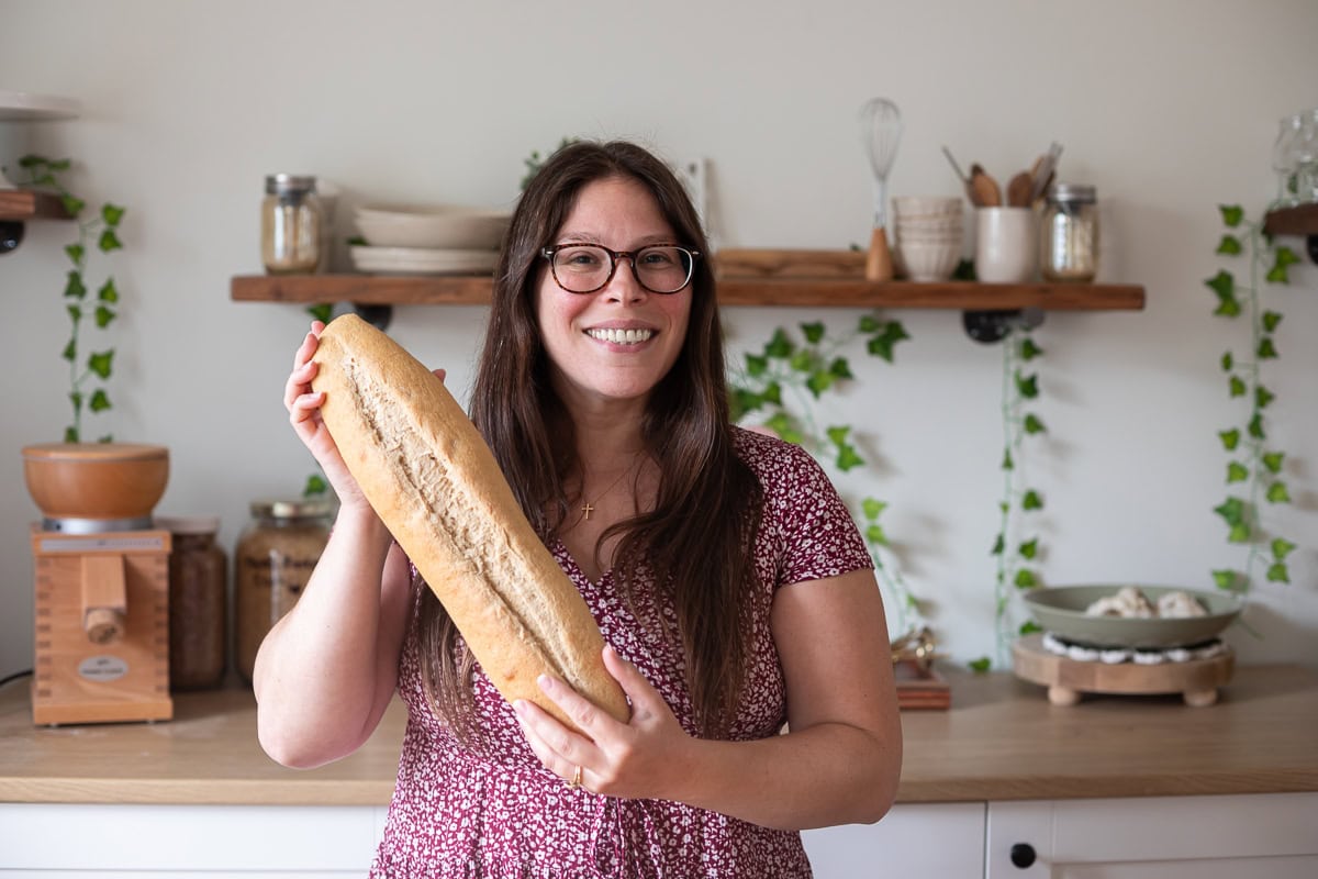 Courtney of Courtney's Sweets holding fresh milled flour french bread.