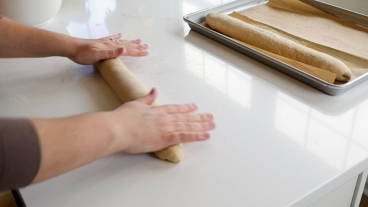 hands rolling and elongating dough.