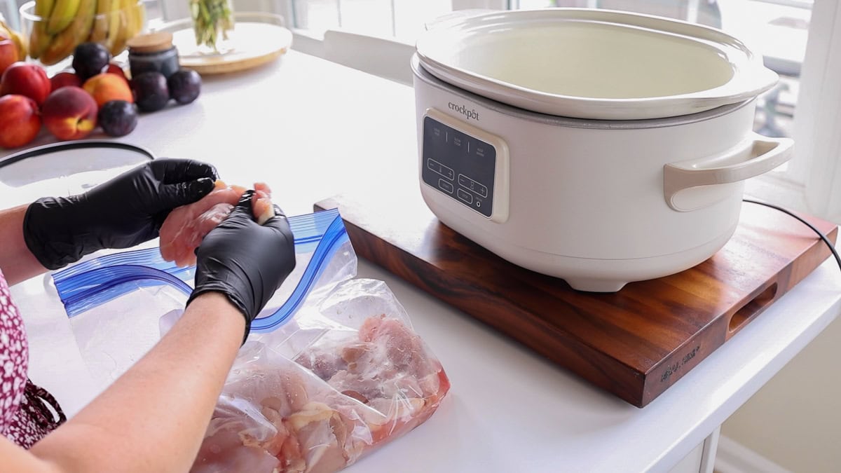 hands cleaning chicken thighs.