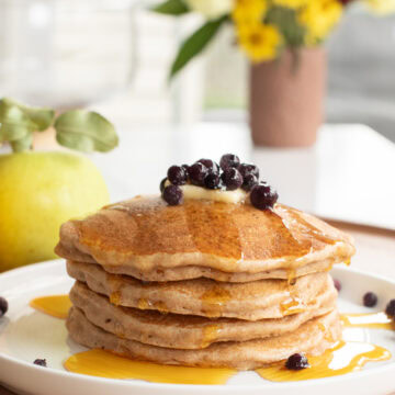 spelt pancakes stacked on a plate.